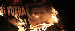 Demonstrators burn a sign with a photograph of Mexico's President Enrique Pena Nieto during a protest in support of the missing 43 trainee teachers in Mexico City December 1, 2014. The popularity of Pena Nieto has sunk amid concerns about his handling of security problems and corruption, polls showed on Monday, in a sign that his ruling party could lose ground in elections next year. Polls noted the sharp drop in his approval rating since the apparent massacre of 43 trainee teachers students and a conflict of interest scandal involving a home being purchased by the first lady. REUTERS/Carlos Jasso (MEXICO - Tags: CRIME LAW CIVIL UNREST EDUCATION POLITICS)